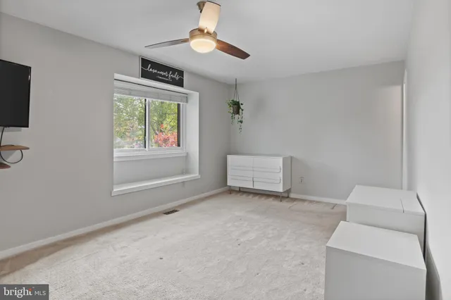 a view of room with a ceiling fan and a bathroom