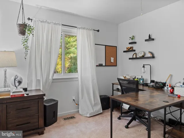a view of a workspace with furniture and a window