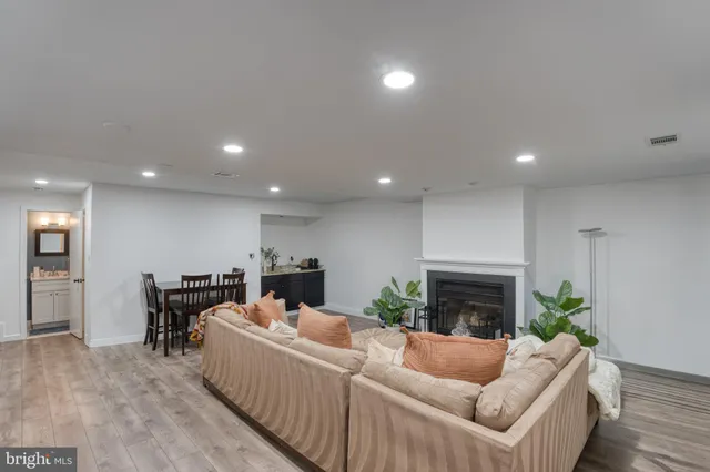a living room with furniture and a dining table with potted plants