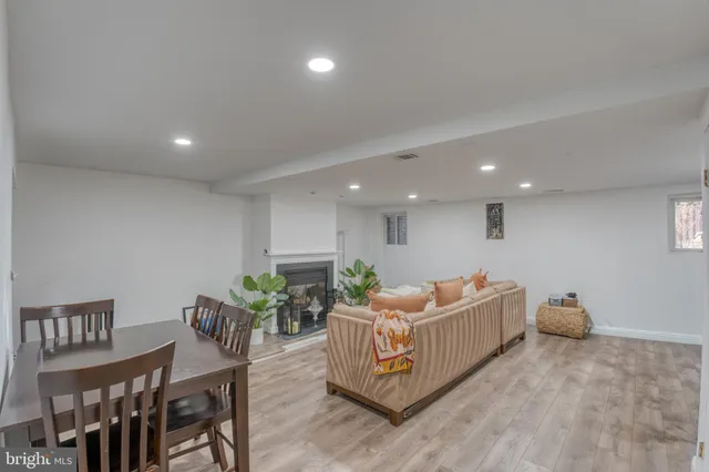 a living room with furniture and a dining table with potted plants