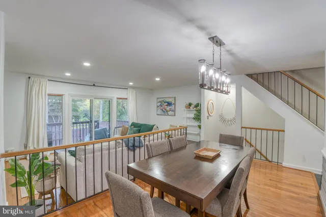 a view of a dining room with furniture a chandelier and wooden floor