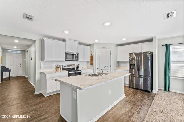 a kitchen with refrigerator a sink and cabinets