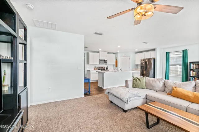 a living room with kitchen island furniture and a chandelier