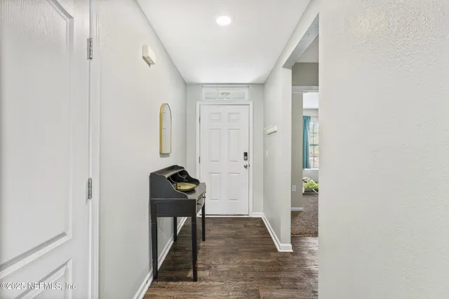 a view of a hallway to a livingroom with furniture