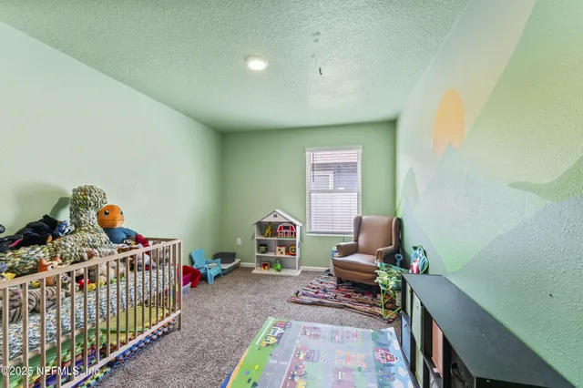 a bedroom with baby crib and a window