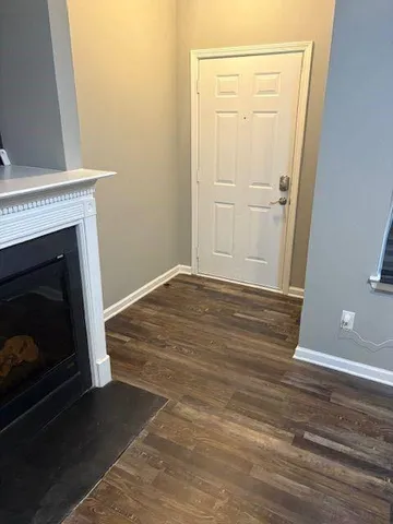 a view of empty room with wooden floor and fireplace
