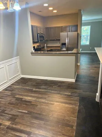a view of kitchen with stainless steel appliances wooden floor