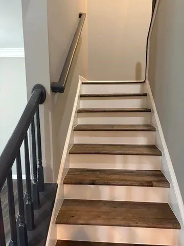 a view of staircase with wooden floor and white walls
