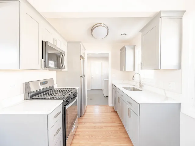 a kitchen with a sink stove and cabinets