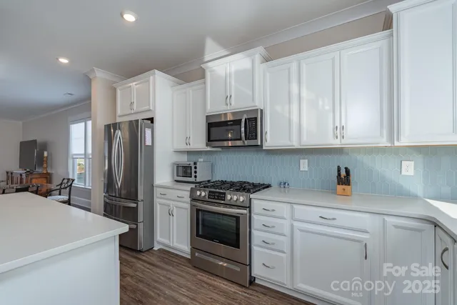 a kitchen with white cabinets and stainless steel appliances