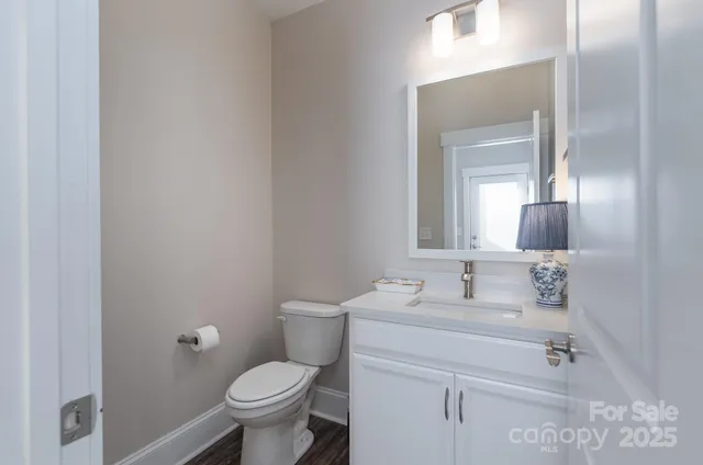 a bathroom with a granite countertop toilet sink and mirror
