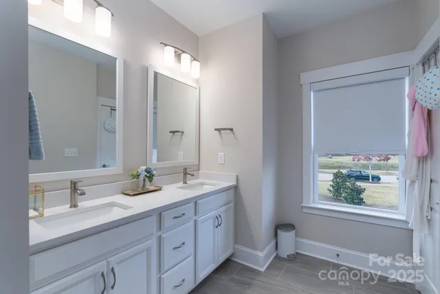 a bathroom with a double vanity sink and a window