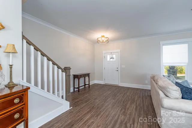 a view of a livingroom with furniture window wooden floor and front door