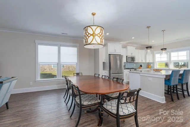 a dining room with furniture a chandelier and wooden floor