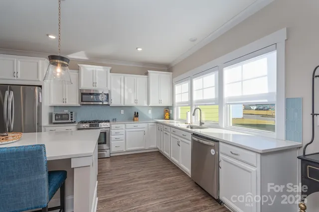 a kitchen with stainless steel appliances granite countertop refrigerator sink and cabinets