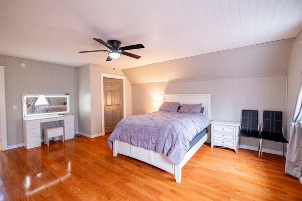 a spacious bedroom with a bed and dresser