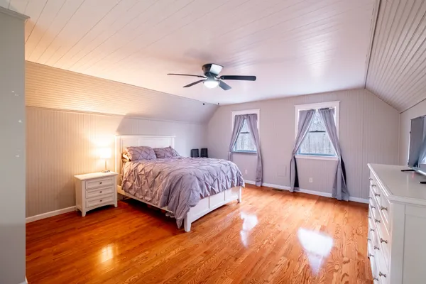 a spacious bedroom with a bed and a ceiling fan