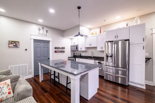 a kitchen with stainless steel appliances granite countertop a refrigerator a sink dishwasher a stove and a refrigerator