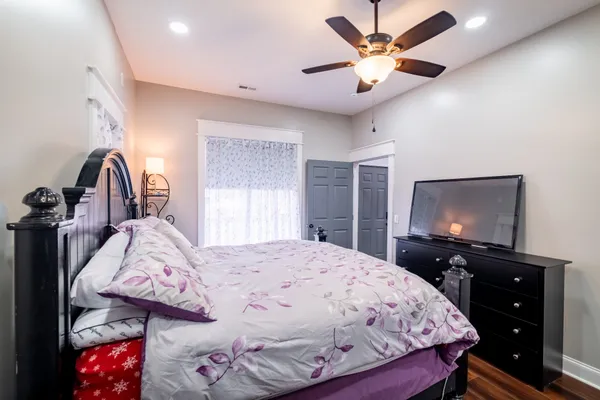 a bedroom with a bed and a flat tv screen on dresser