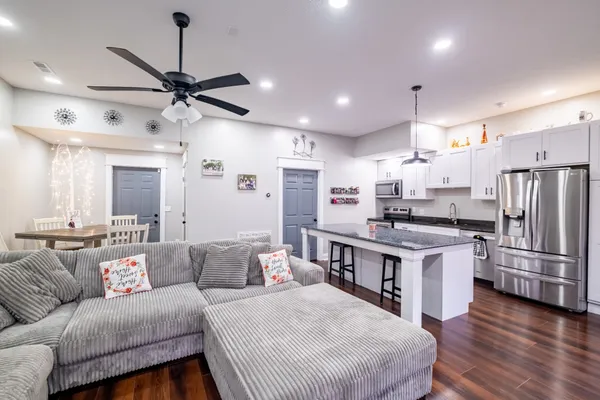 a living room with stainless steel appliances kitchen island furniture and a view of kitchen