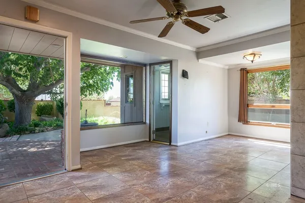 a view of an empty room and window ceiling fan