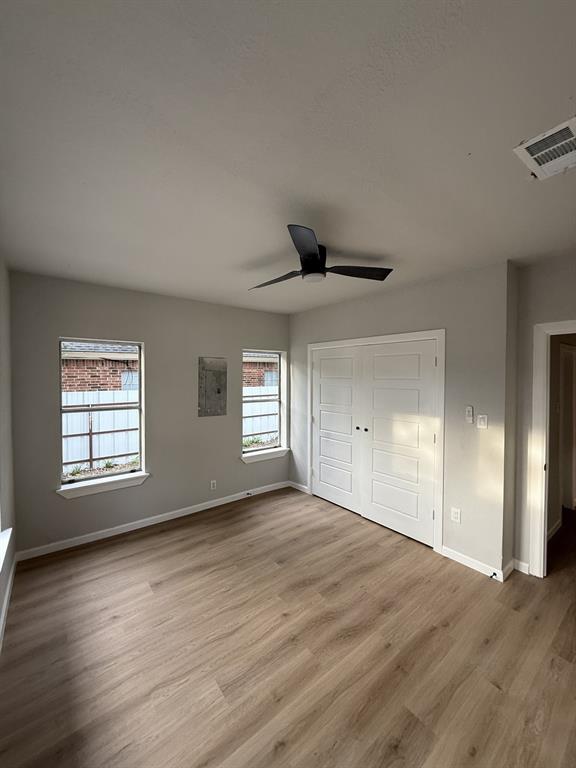 758 Bethpage Avenue Dallas, TX 75217 - Photo 11 of 20 an empty room with wooden floor and windows