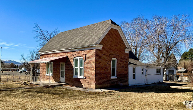 495 North Main Street Beaver, UT 84713 - Photo 2 of 18 View of property exterior featuring brick siding and roof with shingles