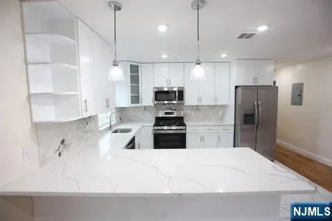 a kitchen with kitchen island a sink stainless steel appliances and cabinets