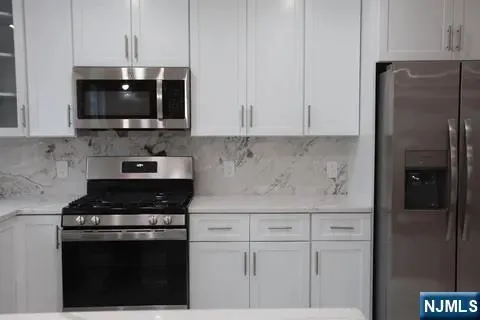 a kitchen with stainless steel appliances a refrigerator a stove a microwave and cabinets