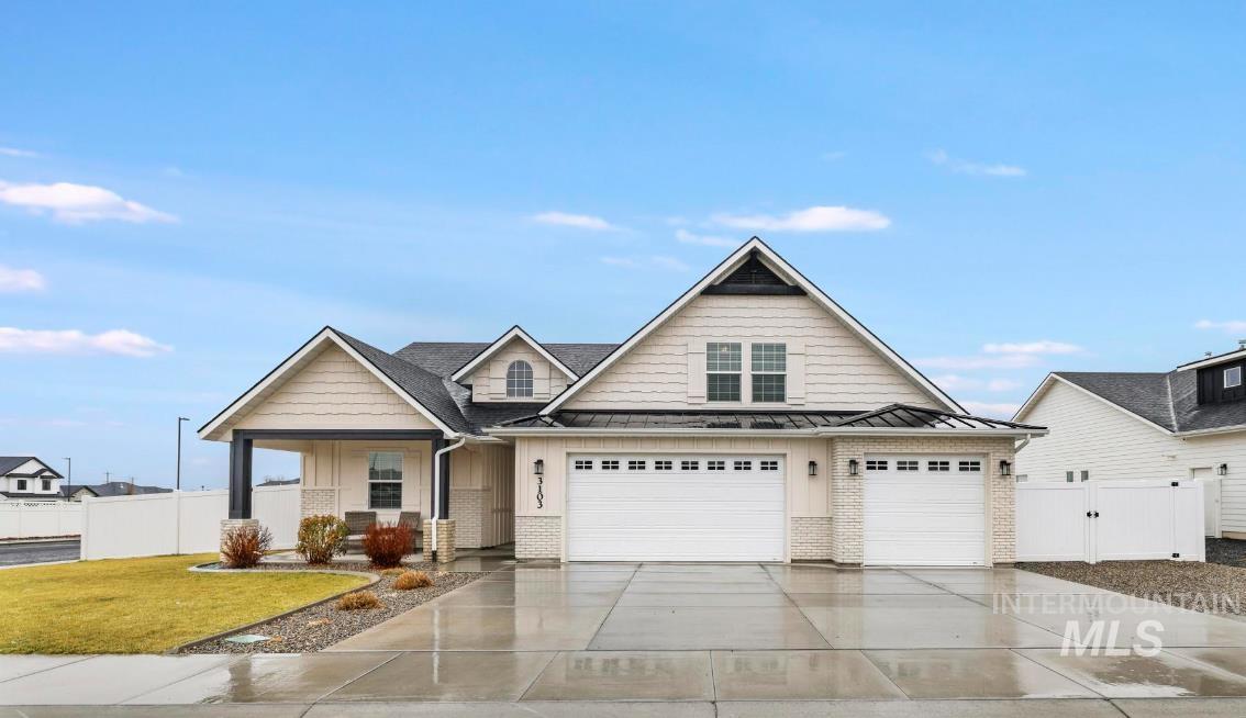 Craftsman-style house featuring concrete driveway, a standing seam roof, brick siding, covered porch, and a garage