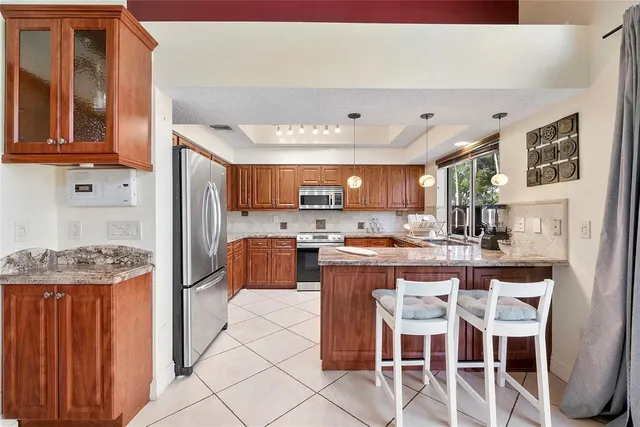 a kitchen with stainless steel appliances kitchen island granite countertop a sink and cabinets