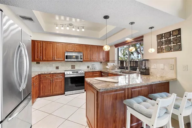 a kitchen with stainless steel appliances granite countertop a stove refrigerator sink and cabinets