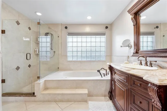 a spacious bathroom with a granite countertop tub sink shower and mirror
