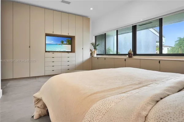 a bedroom with a large bed and a chandelier
