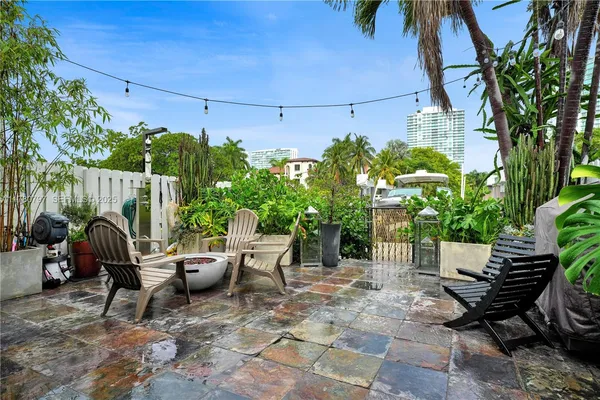a view of a patio with a table and chairs under an umbrella