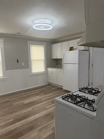 a kitchen with a stove a refrigerator and a window