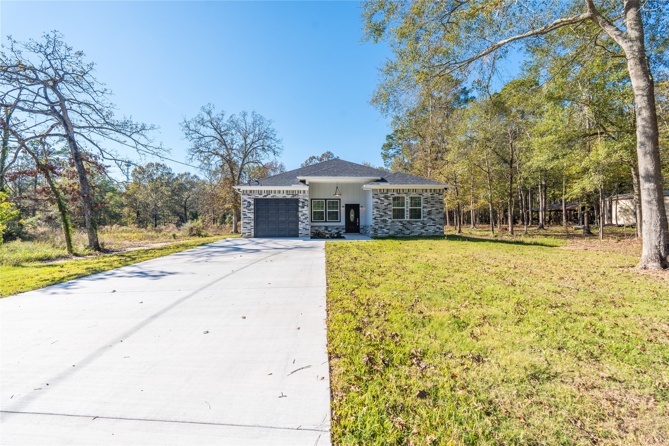 164 County Road 3370 Cleveland, TX 77327 - Photo 2 of 28 a front view of a house with a yard