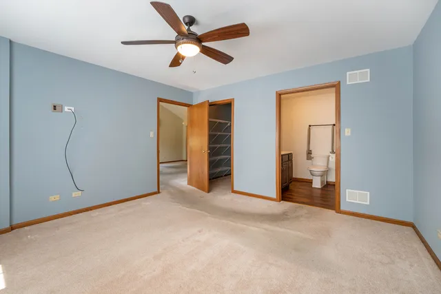 an empty room with closet and a ceiling fan