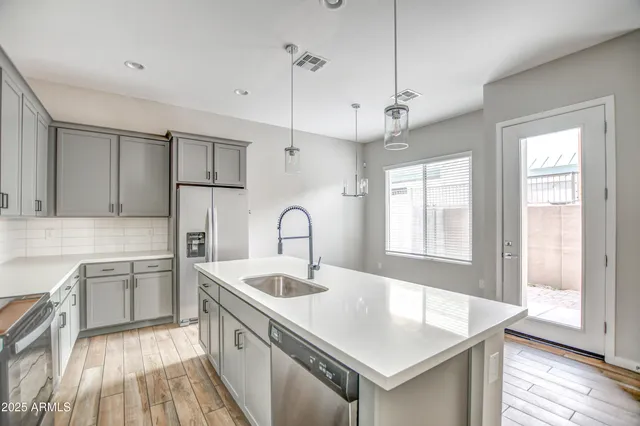 a kitchen with stainless steel appliances granite countertop a sink a stove and refrigerator