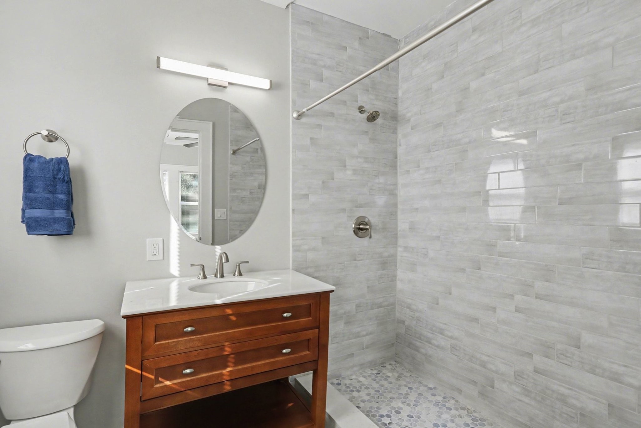 1901 Lexington Street Houston, TX 77098 - Photo 19 of 32 Off of the primary bedroom is a freshly updated bathroom featuring a new vanity w/ Quartz countertop, newly tiled shower, new plumbing fixtures and lighting, and a brand-new toilet.