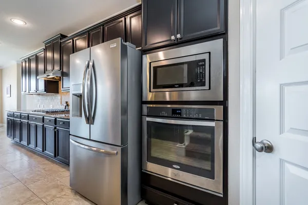 a metallic refrigerator freezer sitting in a kitchen