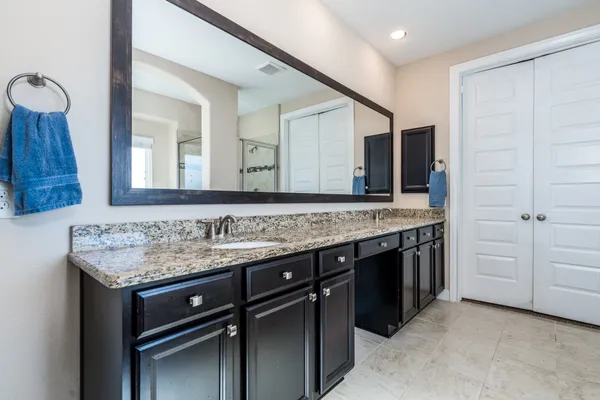 a bathroom with a granite countertop sink and a mirror