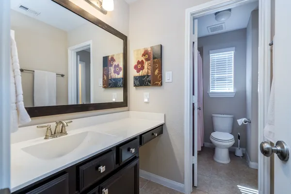 a bathroom with a sink a toilet a shower and a mirror