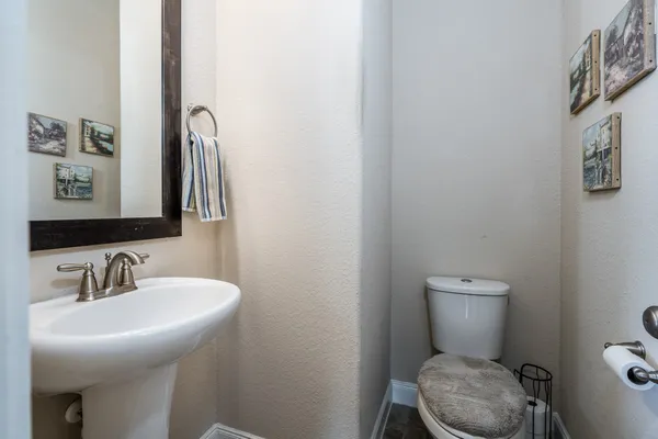 a bathroom with a toilet a sink and mirror