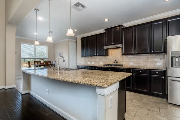 a kitchen with a sink a stove a refrigerator and cabinets