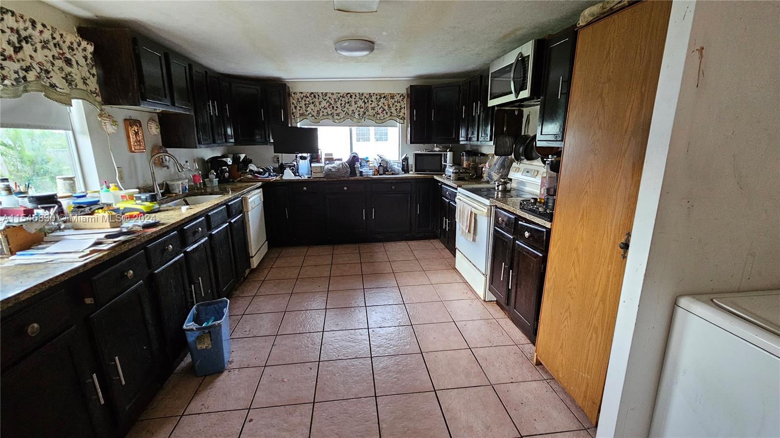 1823 John Road Clewiston, FL 33440 - Photo 23 of 34 a kitchen with a sink a stove top oven a refrigerator and a window