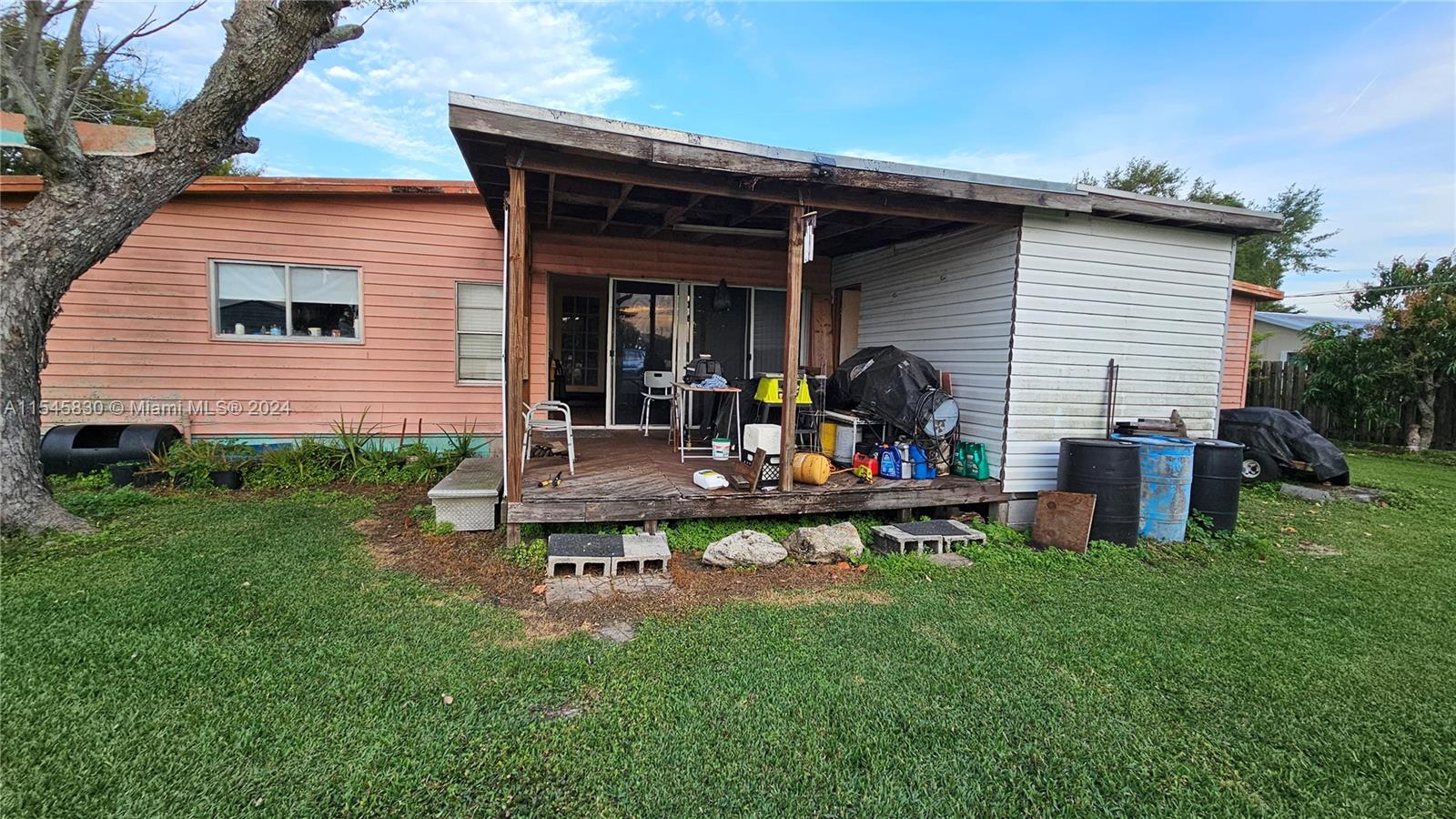 1823 John Road Clewiston, FL 33440 - Photo 28 of 34 a view of a backyard with table and chairs potted plants and a large tree