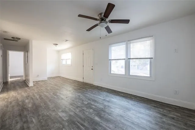 a view of empty room with wooden floor and window
