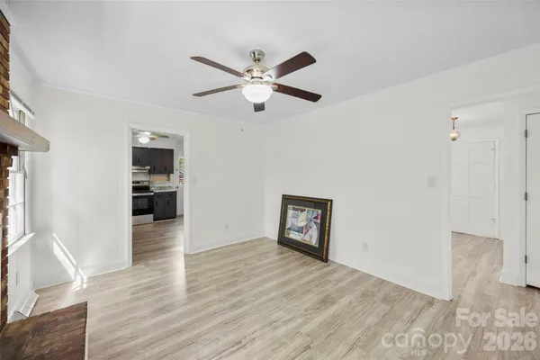 a view of a kitchen with wooden floor and a ceiling fan