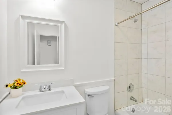 a bathroom with a sink vanity mirror and toilet